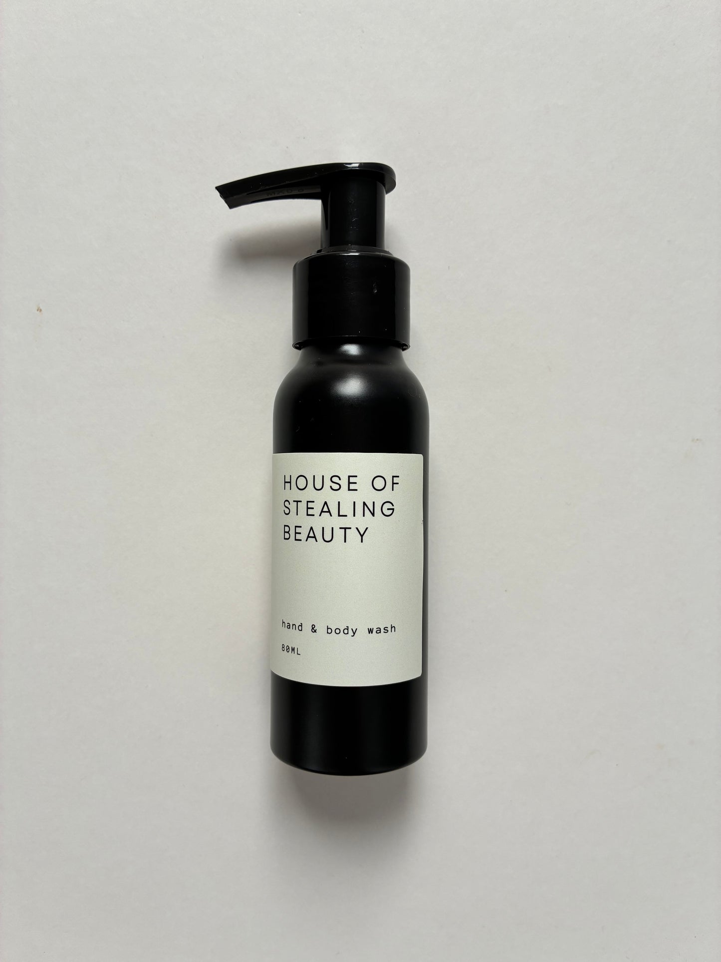 A black pump bottle labeled 'HOUSE OF STEALING BEAUTY hand & body wash'.