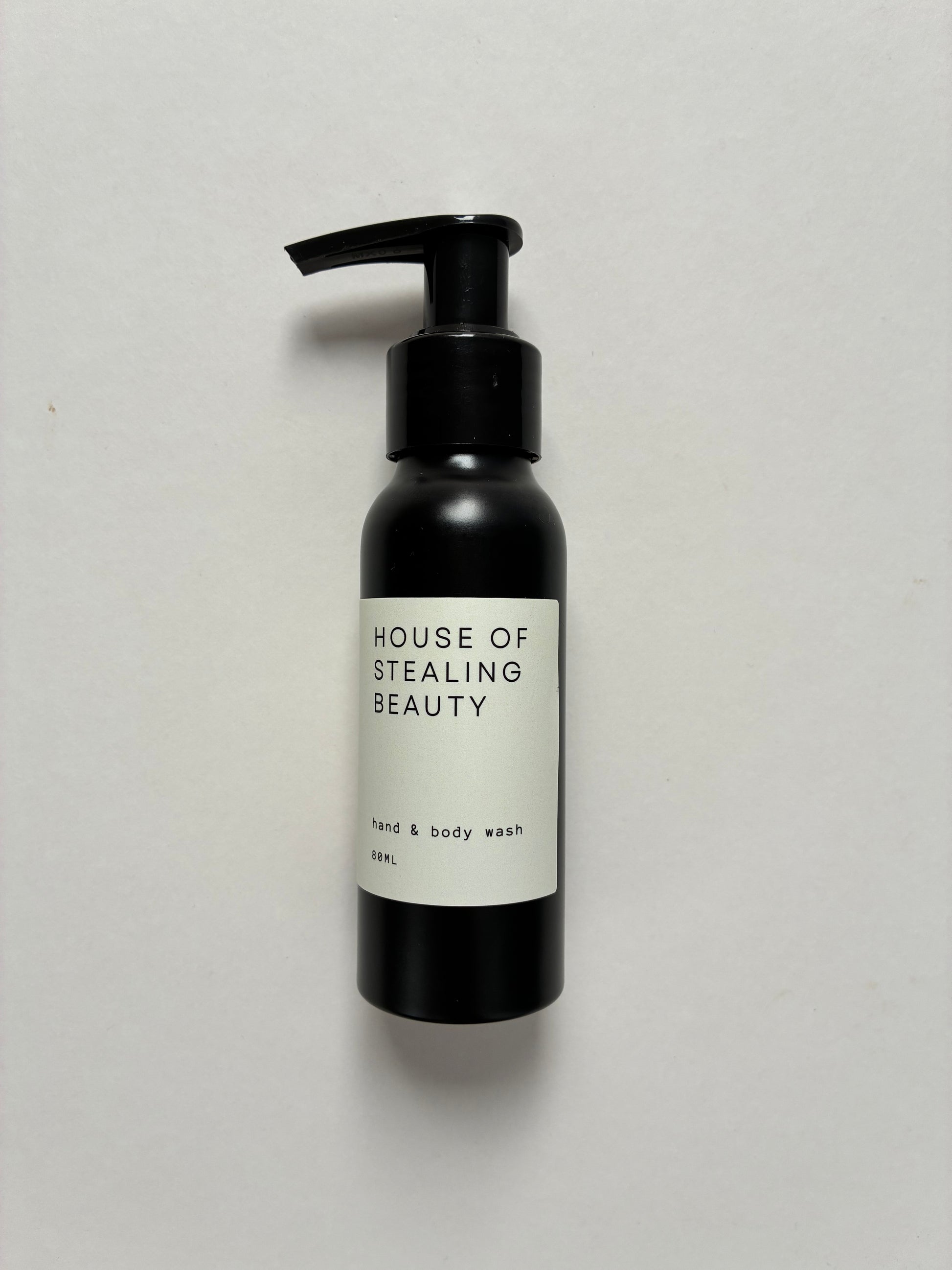 A black pump bottle labeled 'HOUSE OF STEALING BEAUTY hand & body wash'.